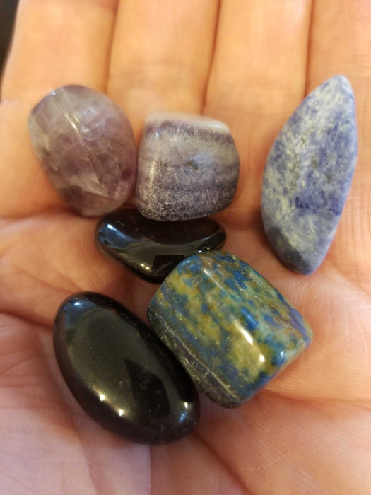 Mercury Retrograde kit displayed in a satin bag, showcasing crystals like Smoky Quartz and Black Tourmaline ideal for spiritual healing and protection.