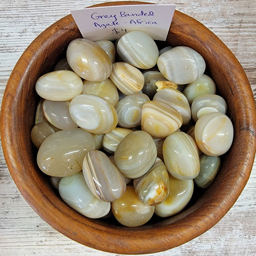Banded Agate Africa tumbled stones showcasing tan and light brown colors with elegant white stripes, perfect for grounding and releasing negative energy.