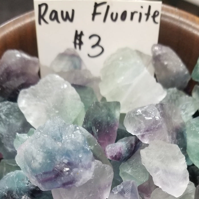 A stunning piece of Fluorite Rough featuring vibrant pink, green, and purple colors, known for its protective and stabilizing properties.
