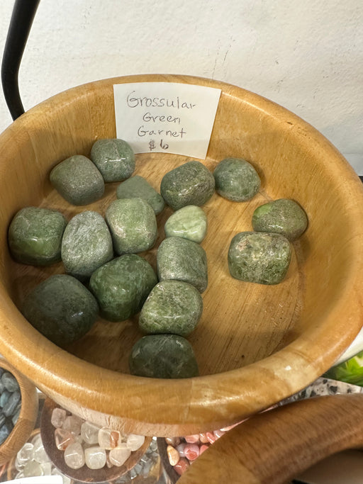 Tumbled stones featuring Grossular Green Garnet, showcasing their vibrant green color and smooth texture, perfect for crystal healing and decorative purposes.