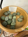 Tumbled stones featuring Grossular Green Garnet, showcasing their vibrant green color and smooth texture, perfect for crystal healing and decorative purposes.